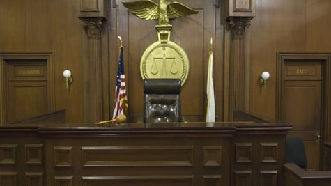 Empty courtroom with chair of judge and flags