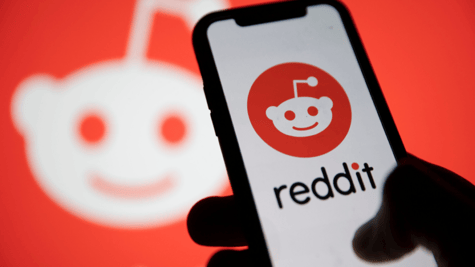 Hand holding mobile with Reddit logo