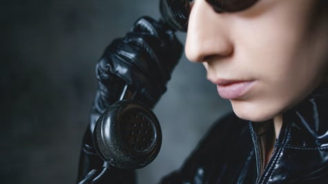 Girl hacker with matrix-type suite with an oldschool phone