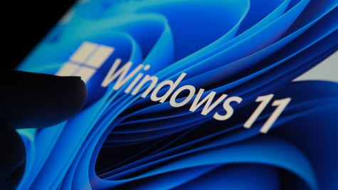 Shadowy hand touching a Windows 11 screen