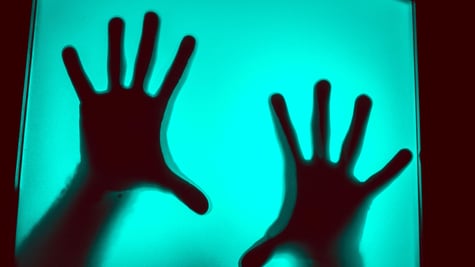Hands behind a computer screen