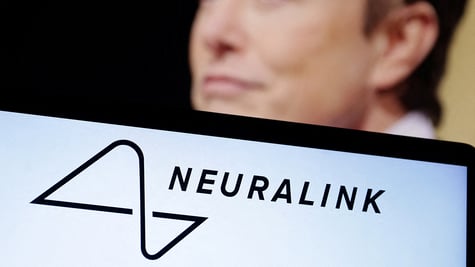 Neuralink logo seen, Elon Musk in the background