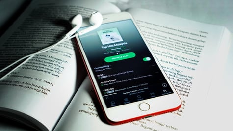 Spotify app seen on a smartphone that is on a book