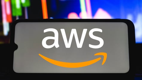 AWS logo on mobile held by silhouetted hand