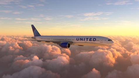 United Airlines Boeing jet flying above clouds