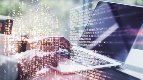 Concept picture of coding in skull shape over reporter typing on laptop
