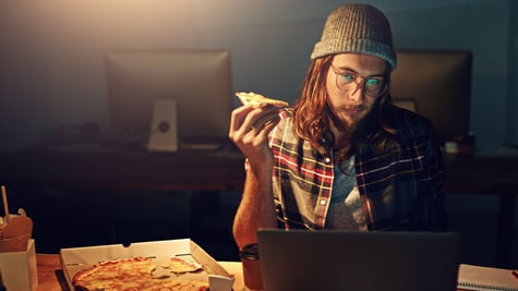 Man eating pizza, computer, work