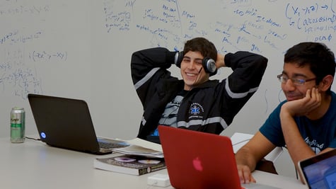 Two male students using laptops
