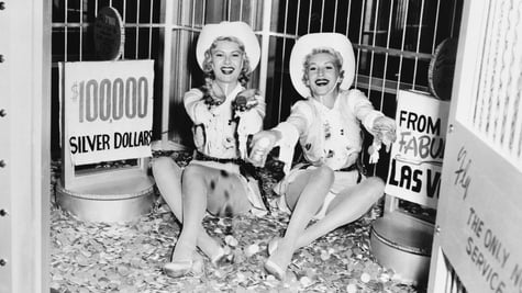 Two beautiful women sitting on silver coins