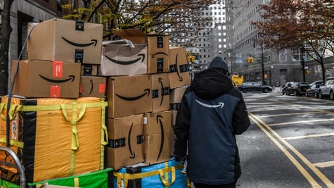Amazon worker pulls packages on cart in New York City