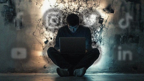A man hunched over a laptop.