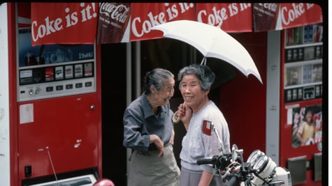 Two Japanese ladies in the 1980's, next to a vending machine.