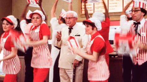 The KFC staff and Colonel Sanders in an ad.