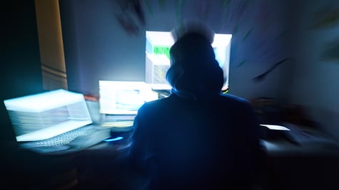 Hacker sitting in from of a lot of computers