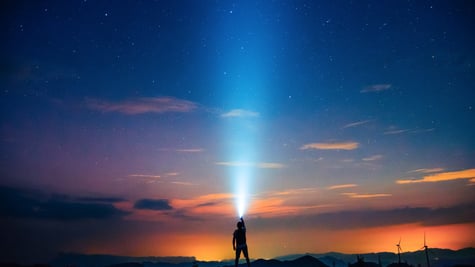 A light being shone on a beautiful night sky.