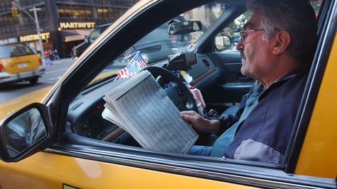 Cab driver reads a newspaper