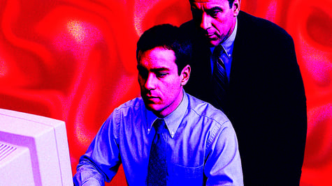 Manager watching over worker looking at screen