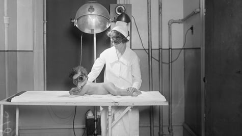 A retro nurse examining a baby.