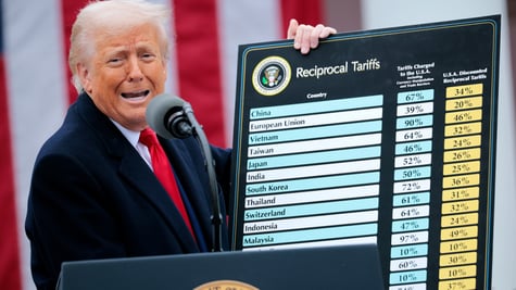 Trump holding up his tariff board.