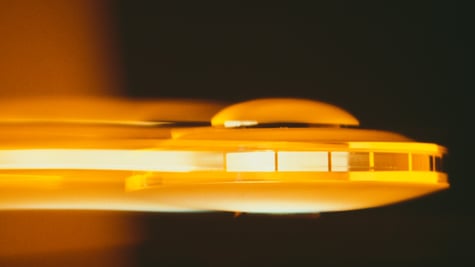A retro photo of a UFO travelling past.