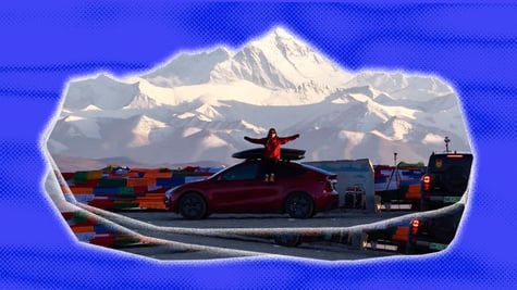 Tesla with a woman sitting on top of it, Mount Everest in the background