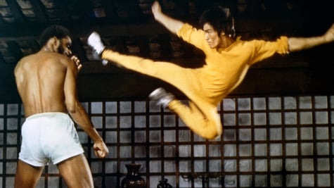 Bruce Lee doing a flying kick.
