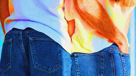 A couple with their hands in each others back pockets.