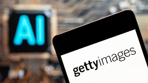 Getty images written in black on white telephone screen, AI blue sign in the back