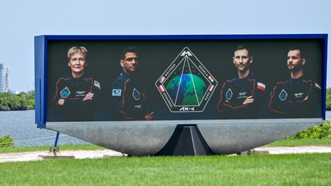 3 men and 1 blonde woman is space suits, poster, green grass