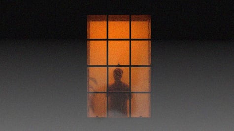 A dark silhouette through an orange window.