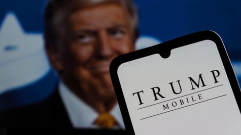 blonde old man in the back, orange tie, trump mobile on white smartphone screen