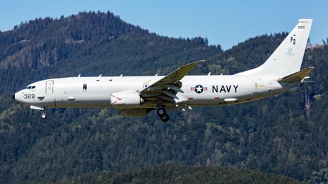 Military plane in air with US Navy logo