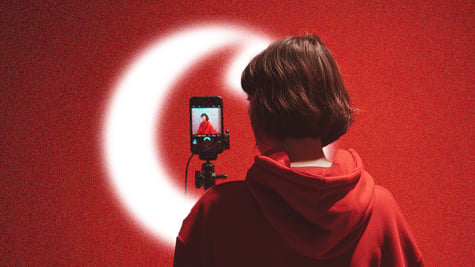 A virtual influencer looking into a phone on a selfie stick with the Vodaphone logo present.