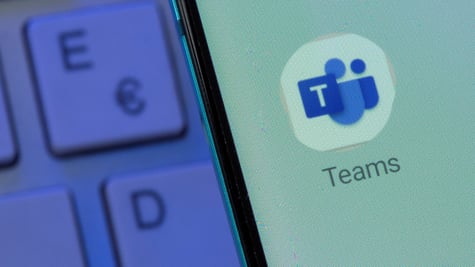 A logo of Microsoft Teams with keyboard in the background