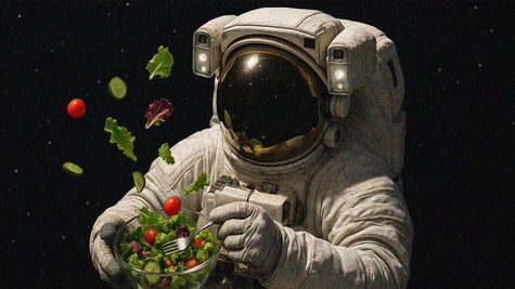 astronaut in black space in white spacesuit, green salad with red tomato