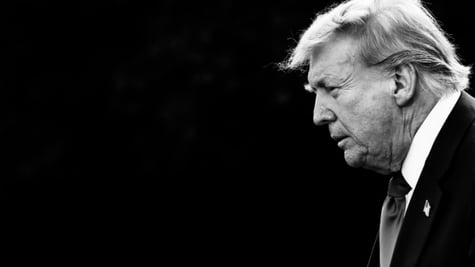 A black and white photo of President Donald rump in the darkness.