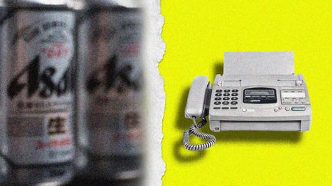 A blurred can of Asahi and a fax machine.