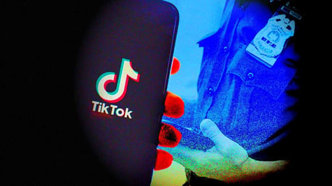 A smartphone with TikTok logo on the screen and a law enforcement officer