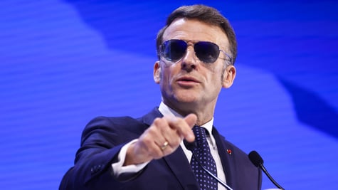 French President Emmanuel Macron wearing sunglasses indoors
