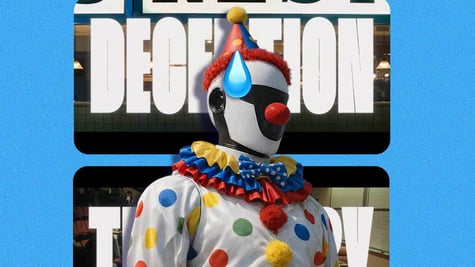A robot dressed as clown and the word "Deception" on the screen behind it