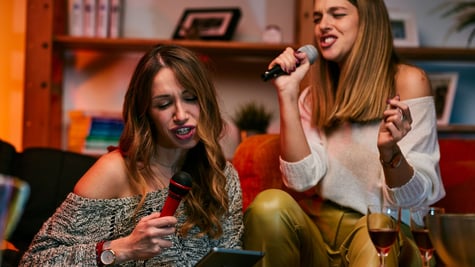 Women singing karaoke at home