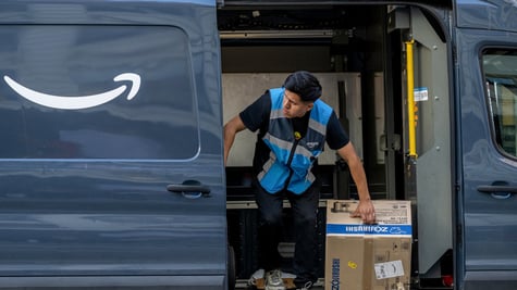 asian man, amazon vest, black hair, brown box, Zojirushi , dark blue amazon delivery trck