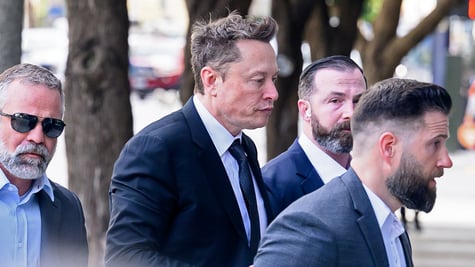 elon musk, profile, walks down the street, three body guards in suits