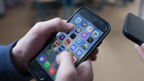 Person holds iPhone in their hands with app screen visible