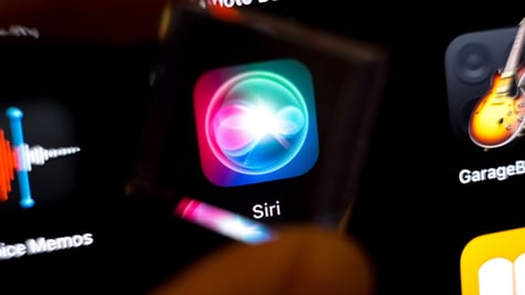 siri app icon on black smartphone screen, guitar on the right