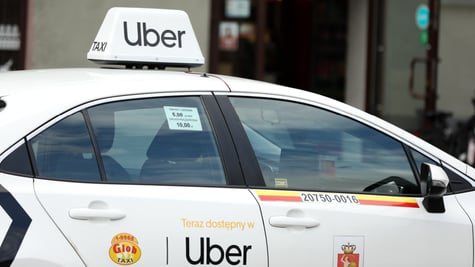 white uber car with sing on door, on top of roof