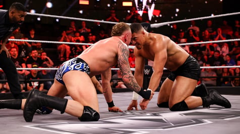 Wrestlers butting heads in the ring.