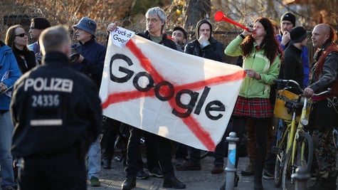 Protesters make noise outside the Umspannwerk building where U.S. tech company Google