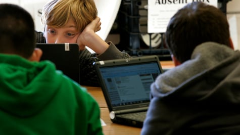three young teens on black laptops, blonde buy, green jumper, screens, 
