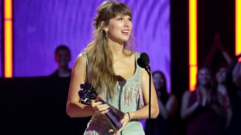 taylor swift, dark blonde almost loose hair, wavy, award statue in hand, grey-greenish strap dress